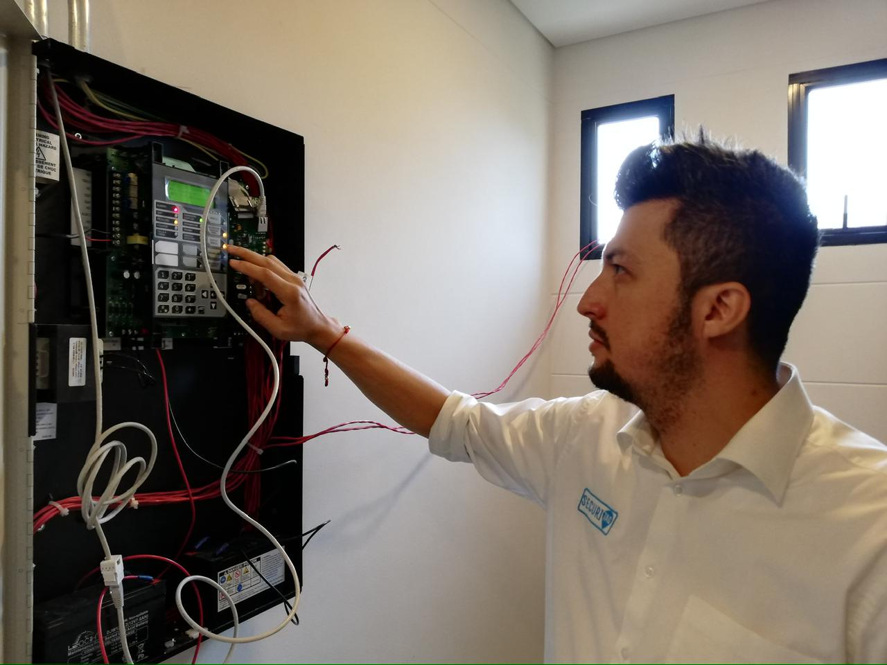 Ingeniero SECURITAG realizando ajustes sobre panel de detección de incendios.
