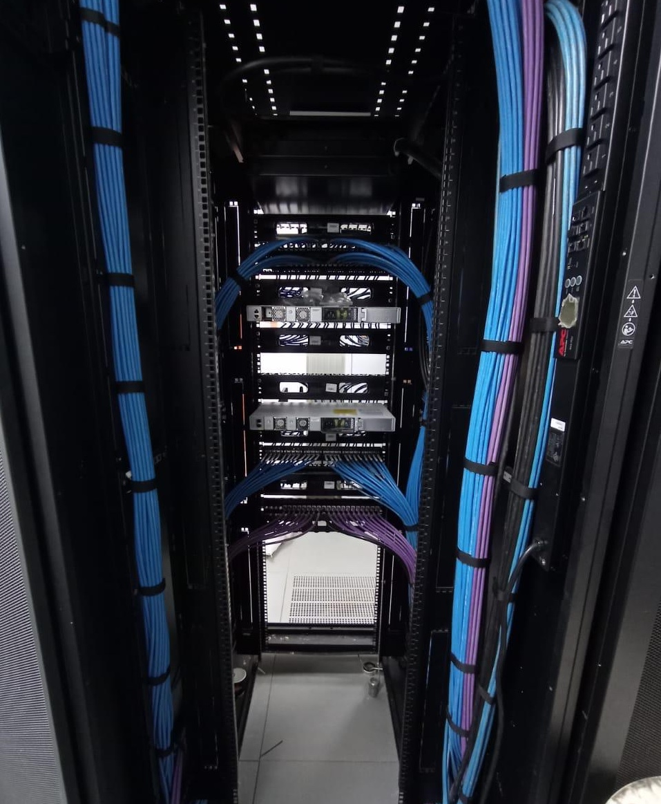 Vista interna de centro de datos con cableado backbone y equipos de comunicaciones.